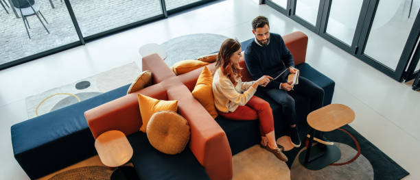 High angle view of two business colleagues working in a lobby stock photo