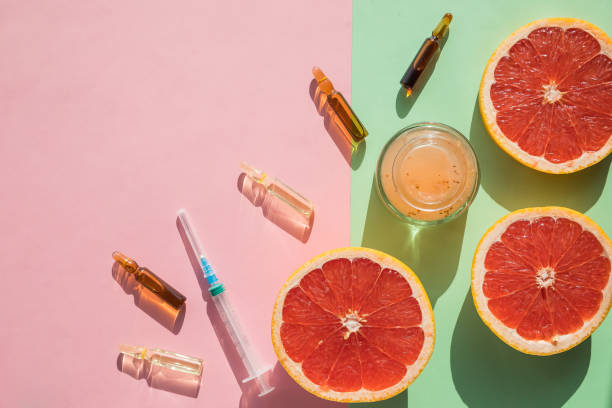high dose vitamin c, ampule for injection, face cream, syringe and fresh juicy orange fruit slides. concept of vitamin,mineral supplement, beauty,cosmetic product and health nutrition. copy space. - food sticks bildbanksfoton och bilder
