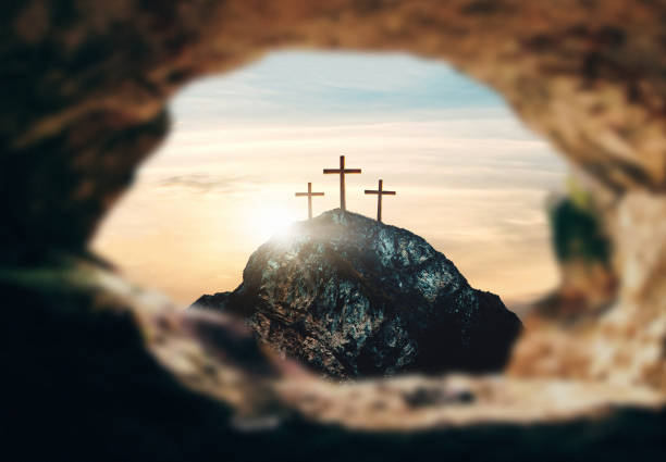 High resolution. Easter Sunday concept: Empty tomb stone with cross on meadow sunrise background. 3d rendering stock photo