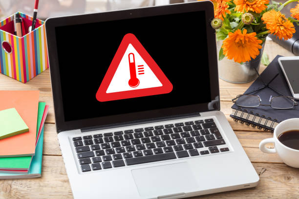High temperature warning sign on a laptop screen.  Computer overheat, overload, hot weather danger stock photo