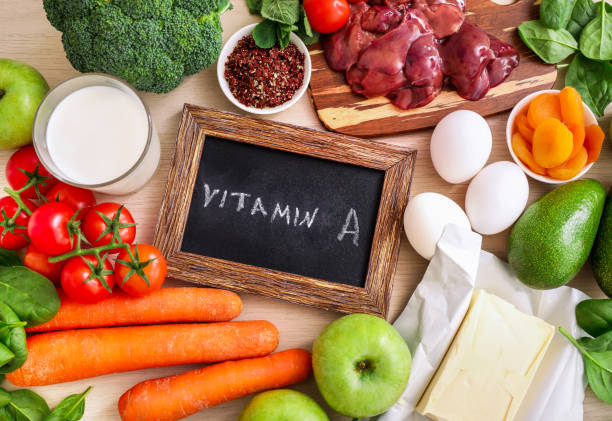 High vitamin A sources assortment Assortment of high vitamin A sources on light background: carrots, broccoli, butter, avocado, dried apricots, eggs, paprika, liver, spinach, apples, tomatoes, milk. Top view. vitamin stock pictures, royalty-free photos & images