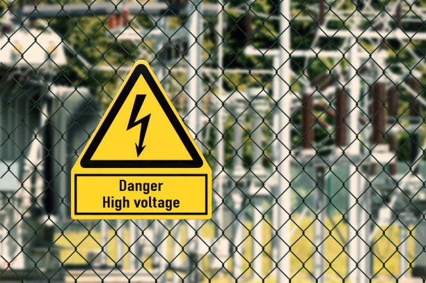High voltage electricity Symbol Electrical hazard sign placed on a fence of an electrical substation high voltage sign stock pictures, royalty-free photos & images