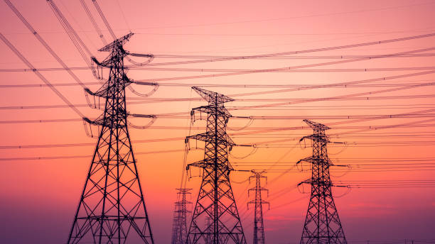 High voltage power tower and nature landscape at sunset stock photo