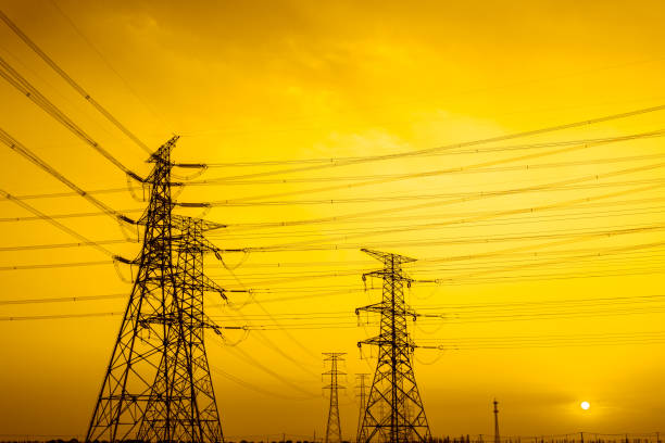 High voltage power tower and nature landscape at sunset stock photo