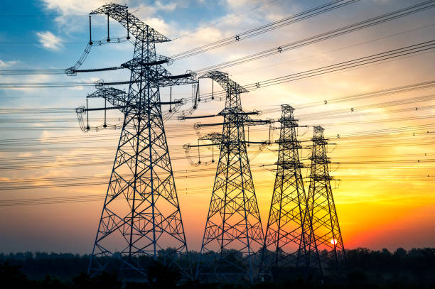 High-voltage wire tower at dusk stock photo