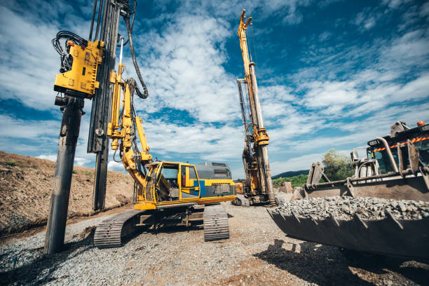 Highway construction site with heavy duty machinery. Two Rotary drills, bulldozer and excavator working Highway construction site with heavy duty machinery. Two Rotary drills, bulldozer and excavator working drill stock pictures, royalty-free photos & images