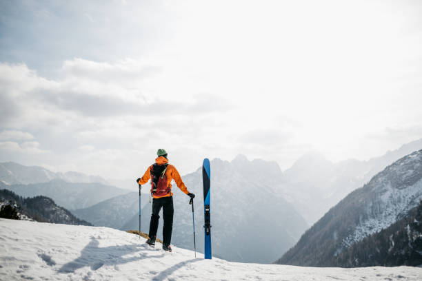 Hiker enjoying the views in the mountains before skiing back to the valley stock photo