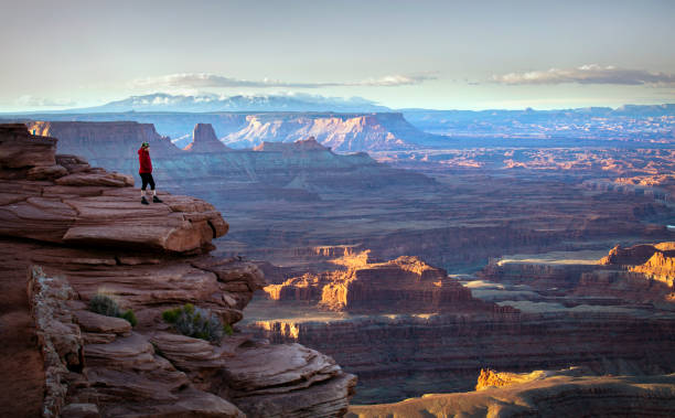 Hiker overlooking canyons at sunrise stock photo