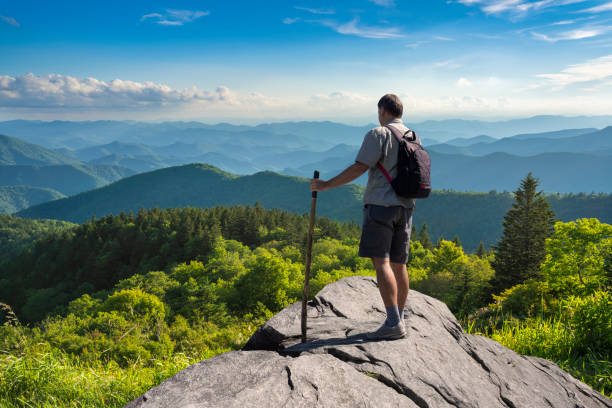 Hiker standing on top of the mountain at beautiful view. stock photo