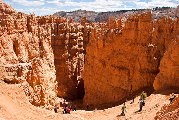 Hikers Descend into the Wall Street Slot Canyon Bryce Canyon National Park, Utah, USA - May 12, 2011: Hikers descend into the Wall Street slot canyon on the Navajo Loop Trail. jeff goulden bryce canyon national park stock pictures, royalty-free photos & images