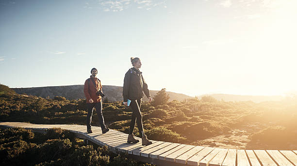 Hiking at first light Shot of a young couple hiking along a trail in the mountains tasmania photos stock pictures, royalty-free photos & images