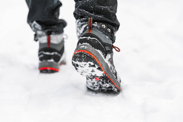 Hiking boot closeup, winter walking in snow. stock photo