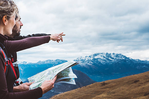 Hiking couple with map in mountain stock photo