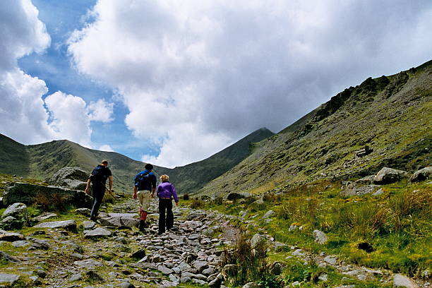 hiking in Carrauntoohil three people climbing the highest mountain in Ireland, Carrauntoohil in County Kerry county kerry stock pictures, royalty-free photos & images