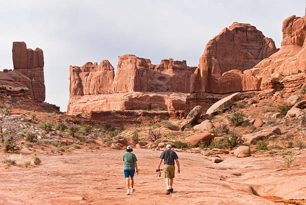 Hiking in Park Avenue Arches National Park, Utah, USA - May 16, 2012: This couple is hiking on the Park Avenue Trail. jeff goulden mojave desert stock pictures, royalty-free photos & images