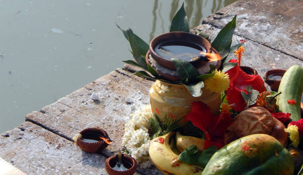 Hindu devotee offer prasad ,fruits,vegetables and other items and light lamp or diya, to pray sun God,at a lake,in Chhath Puja festival Hindu devotee offer prasad ,fruits,vegetables and other items and light lamp or diya, to pray sun God,at a lake,in Chhath Puja a tradional festival chhath stock pictures, royalty-free photos & images