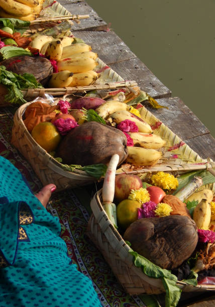 Hindu devotee offer prasad ,fruits,vegetables and other items and light lamp or diya, to pray sun God,at a lake,in Chhath Puja festival Hindu devotee offer prasad ,fruits,vegetables and other items and light lamp or diya, to pray sun God,at a lake,in Chhath Puja a traditional annual festival chhath stock pictures, royalty-free photos & images