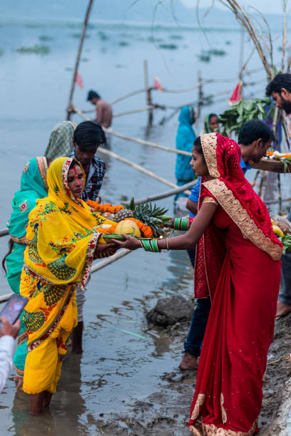 Hindu Devotees Celebrate Chhath Puja Festival GHAZIABAD, UTTAR PRADESH/INDIA - NOVEMBER 2019 : Portrait shoot of Ladies offer prayers while standing in the river bank during sunset to mark Chhath Puja celebrationat Hindon River chhath stock pictures, royalty-free photos & images