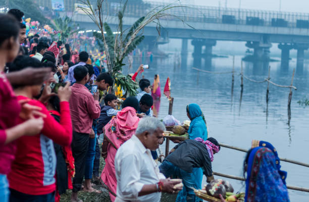 Hindu Devotees Celebrate Chhath Puja Festival GHAZIABAD, Uttar Pradesh/India - NOVEMBER 2019 : People gather to worship the Sun god at Hindon River during the festival of Chhath Puja chhath stock pictures, royalty-free photos & images