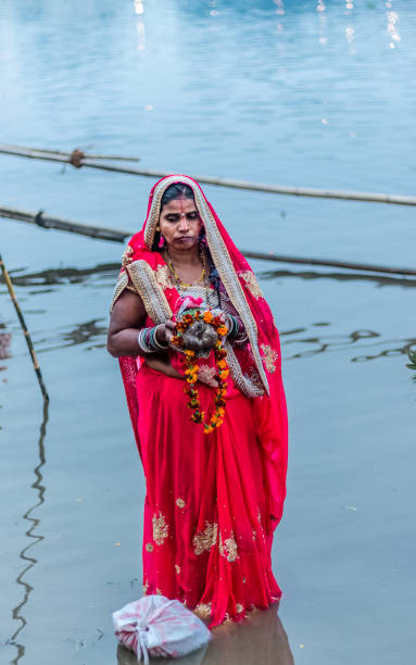 Hindu Devotees Celebrate Chhath Puja Festival GHAZIABAD, UTTAR PRADESH/INDIA - NOVEMBER 2019 : Portrait shoot of Ladies offer prayers while standing in the river bank during sunset to mark Chhath Puja celebrationat Hindon River chhath stock pictures, royalty-free photos & images