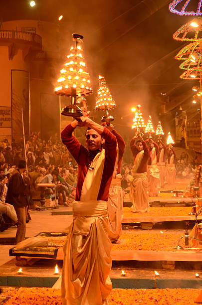 Hindu priest performing religious Ganga Aarti Varanasi, India - February 6, 2014: Hindu priest performing religious Ganga Aarti ritual (Ganges puja) ghat stock pictures, royalty-free photos & images