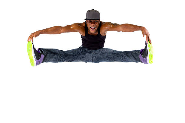 Hip Hop Dancer Jumping or Parkour Hip hop dancer jumping or parkour freerunner on a white background.  The man is dressed in urban hip hop style outfit.  He is muscular and fit.  The man is active but the movement is frozen with a fast shutter. doing the splits stock pictures, royalty-free photos & images