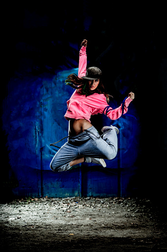 Female Hip-hop dancer jumping. About 25 years old, Caucasian woman.