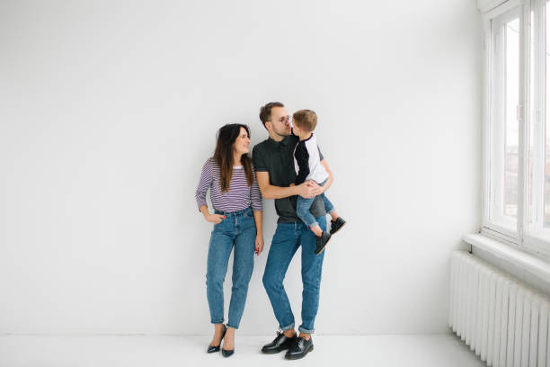Hipster father, mother holding baby boy over white isolated background stock photo