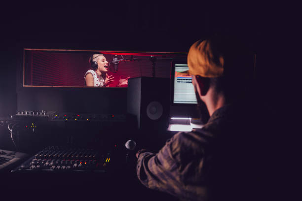 Hipster pop music artist recording song at professional music studio Hipster rock music singer and music producer recording song in professional music recording studio producer stock pictures, royalty-free photos & images