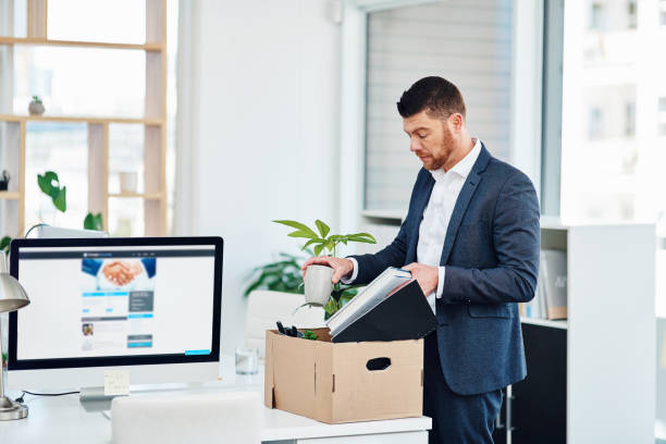 His time here has come to an end Cropped shot of a handsome young businessman packing up his desk at work after being let go being fired photos stock pictures, royalty-free photos & images