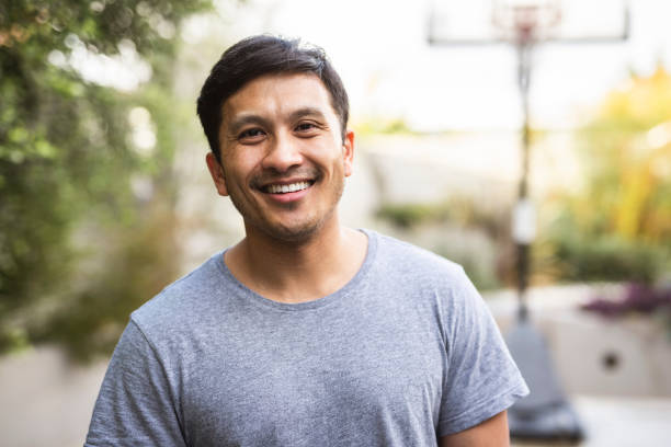 Hispanic adult standing outside and smiling stock photo