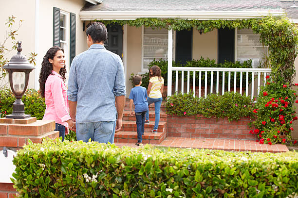 Hispanic family outside home Hispanic family standing in front garden outside home in front of stock pictures, royalty-free photos & images