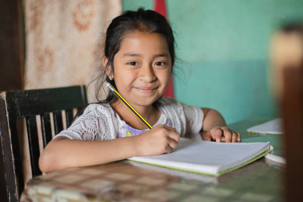 Hispanic girl doing homework at home in rural area - Mayan girl learning to read and write Hispanic girl doing homework at home in rural area - Mayan girl learning to read and write peru girl stock pictures, royalty-free photos & images