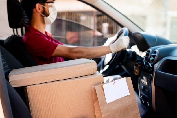 Hispanic male courier with orders in car. Food delivery service stock photo