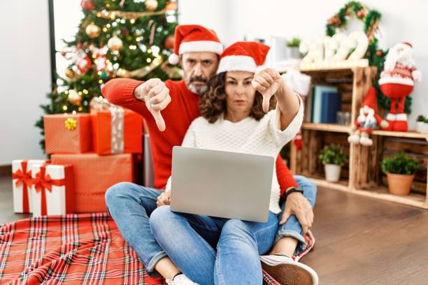 hispanic-middle-age-woman-and-mature-man-using-laptop-sitting