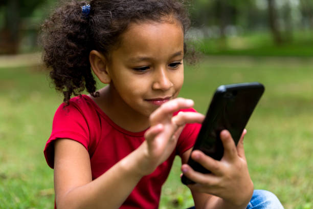 Hispanic or latino children using her mobile phone People collecion cute puerto rican girls stock pictures, royalty-free photos & images