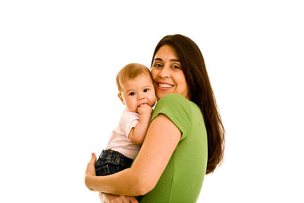 Hispanic smiling female hugging infant looking at camera stock photo