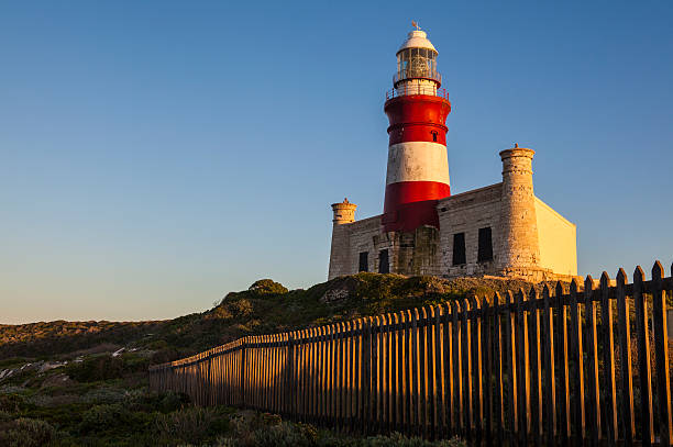 Historic Cape Agulhas lighthouse at sunrise stock photo