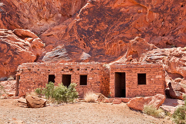 Historic Civilian Conservation Corps Cabins Valley of Fire is Nevada’s oldest state park. The park gets its name from the red rock formations which appear to be on fire as the sun sets. These Aztec sandstone rocks were formed from sand dunes 150 million years ago. The region was further shaped by uplifting and faulting followed by extensive erosion. The Anasazi people visited this area from about 300 BC to 1150 AD. Scarcity of water would have prevented their living here but they probably hunted, gathered food and performed religious ceremonies. There are several sites where their petroglyphs can still be seen. In 1931, 8,760 acres of federal land was transferred to the state of Nevada. In 1933, the Civilian Conservation Corps (CCC) began developing the park which opened in 1934. The CCC continued working on the park into the early 1940’s and built campgrounds, trails, visitor cabins, ramadas and roads. In 1935, the Nevada State Legislature designated the area as Valley of Fire State Park. In 1968, the park was recognized as a National Natural Landmark. This scene of the historic CCC cabins was photographed at Valley of Fire State Park which is located 50 miles northeast of Las Vegas near Overton, Nevada, USA. jeff goulden valley of fire state park stock pictures, royalty-free photos & images