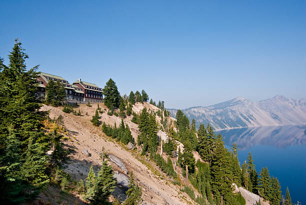 Historic Lodge Above Crater Lake Crater Lake Lodge was built in 1915 to provide overnight accommodation for visitors to Crater Lake. The lodge is located on the southwest rim, 1,000 feet above Crater Lake. In 1967, the National Park Service acquired the Crater Lake Lodge and it was placed on the National Register of Historic Places in 1981. The building continued to deteriorate due to the harsh environment and lack of funds for maintenance. Despite being listed on the National Register of Historic Places, the National Park Service scheduled the building to be demolished. The decision was later reversed due to public opposition. In 1988, the National Park Service approved a plan to rebuild the lodge as part of a comprehensive effort to redevelop the entire Rim Village. Crater Lake Lodge is located in Crater Lake National Park, yyy, USA. jeff goulden stock pictures, royalty-free photos & images