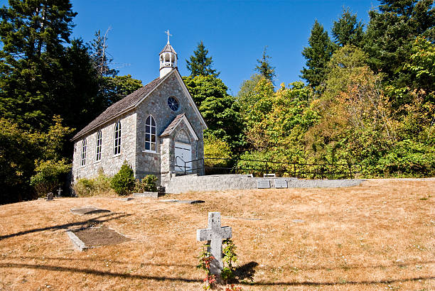 Historic Stone Church and Cemetery The Canadian Gulf Islands are part of a rocky archipelago in the Strait of Georgia between Vancouver Island and the mainland of British Columbia. The larger archipelago includes the San Juan Islands in the United States. The Gulf Islands are perhaps best known for their natural beauty, farms, wineries, rural lifestyle and Mediterranean climate. Activities to be enjoyed in the Gulf Islands includes boating, kayaking, hiking, camping and wildlife viewing. This area was charted by British explorer George Vancouver during his 1791-1795 expedition. The name “Gulf Islands” comes from “Gulf of Georgia,” the original name used by Vancouver on his maps. This scene was photographed at Saint Paul's Catholic Church (1880) near Fulford on Saltspring Island, British Columbia, Canada. jeff goulden church stock pictures, royalty-free photos & images