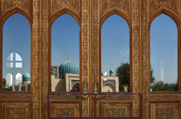 storica porta in legno con vetro che riflette le moschee barak-chan a tashkent - barak foto e immagini stock