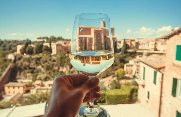Historical church Basilica of San Domenico in reflection of a glass of wine. Ancient city Siena, Italy stock photo
