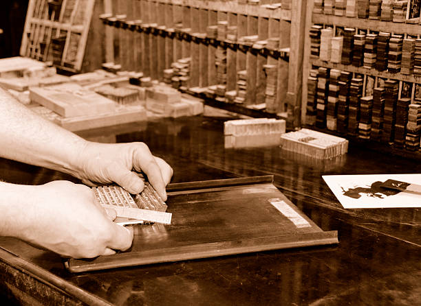 History of printing "Printer composing hot metal type on composing stone, reglet case in background. Sepia tone. Images in this series are a tribute to letterpress printing - art and craft of its own." linotype stock pictures, royalty-free photos & images