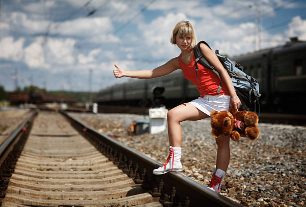 hitchhiking young woman on train tracks holding teddy bear - teddy ray stok fotoğraflar ve resimler
