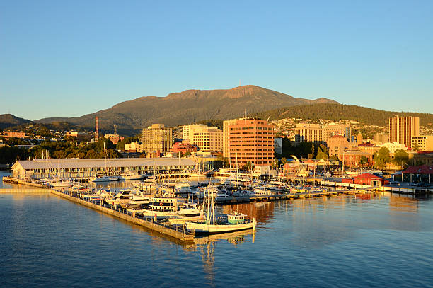 Hobart And Sullivans Harbor At Dawn A view of Sullivans Harbor in Hobart, Tasmania on a clear day with Mt. Wellington rising in the background. The Broadcast Australia Tower, or NTA, sticks up on Mt. Wellington like a rocket poised for takeoff, tasmania photos stock pictures, royalty-free photos & images