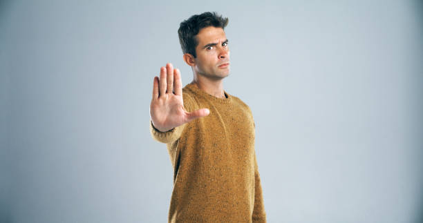 Hold it right there! Studio shot of a handsome young man gesturing to stop against a gray background stop gesture stock pictures, royalty-free photos & images