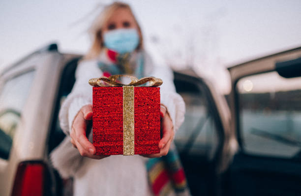 halten sie ein weihnachtsgeschenk aftershopping während covid-19 - auto packen für den urlaub winter stock-fotos und bilder