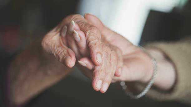 Holding hand of very old woman-home caregiver Very Shallow DOF. Developed from RAW; retouched with special care and attention; Small amount of grain added for best final impression. 16 bit Adobe RGB color profile. Photos are made for this photo shooting, and there are no recognizable people. memory loss stock pictures, royalty-free photos & images