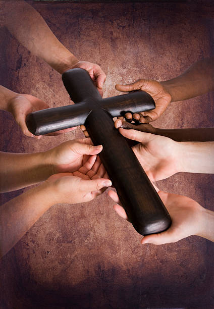 Holding Rugged Cross Together stock photo